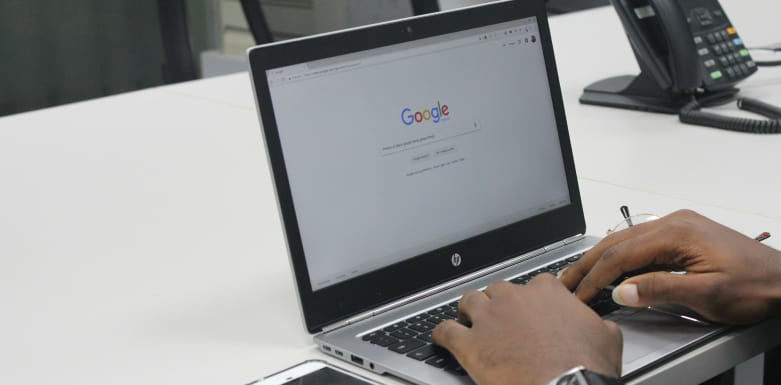 Pessoa fazendo uma busca no Google pelo computador.