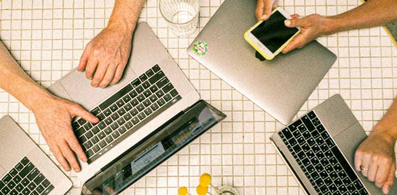 O que é marketing digital? Saiba tudo sobre essa estratégia! Três pessoas usando computadores.