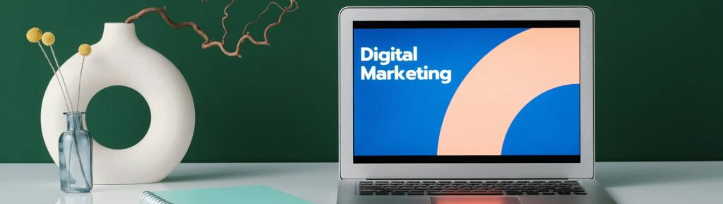 Computador aberto numa tela com ilustração de marketing digital.