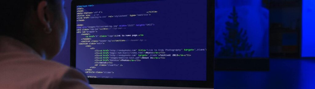 Desenvolvedor trabalhando com código em computador para otimização de SEO.