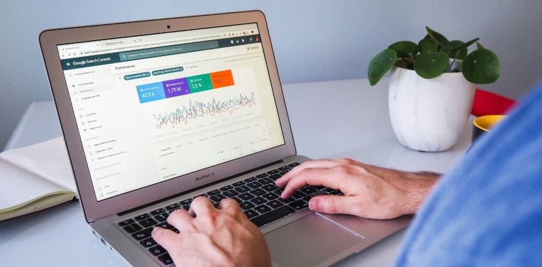 Como configurar Google Search Console: veja o passo a passo Pessoa com as mãos no teclado, enquanto computador está aberto no GSC.