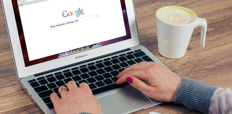 Intenção de busca: saiba como influencia no SEO Mulher fazendo busca no Google pelo computador.