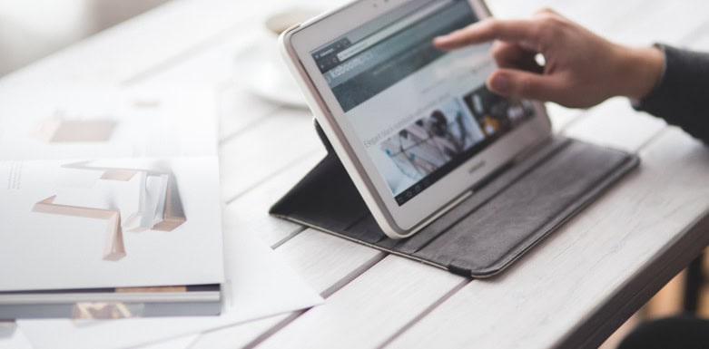 Autoridade de domínio: como a métrica auxilia na relevância em buscas orgânicas Pessoa aproximando o dedo da tela do tablet.