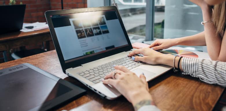 Autoridade de domínio: como a métrica auxilia na relevância em buscas orgânicas Mulher com as mãos no teclado do notebook.