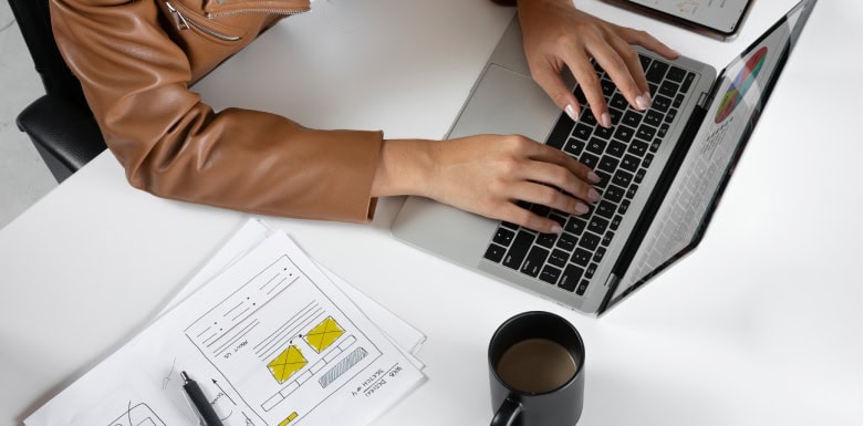 Como fazer a otimização de landing pages? Mãos digitando no teclado do computador.