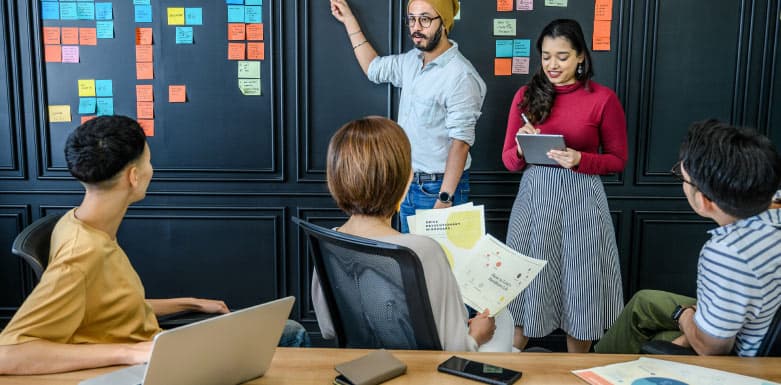 Atributo Href: saiba como afeta o seu projeto de SEO! Equipe em reunião, usando post it colados na parede para alinhar os pontos.