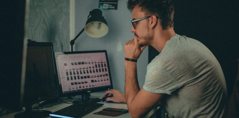 Carregamento assíncrono: conheça mais sobre o assunto! Homem vendo pasta de arquivos no computador.