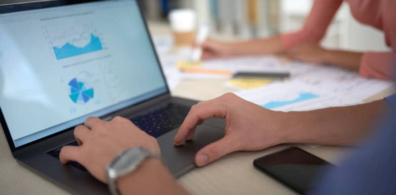 Data-Driven SEO: tudo que você precisa saber sobre o assunto Homens com as mãos no teclado do computador, vendo dados na tela.